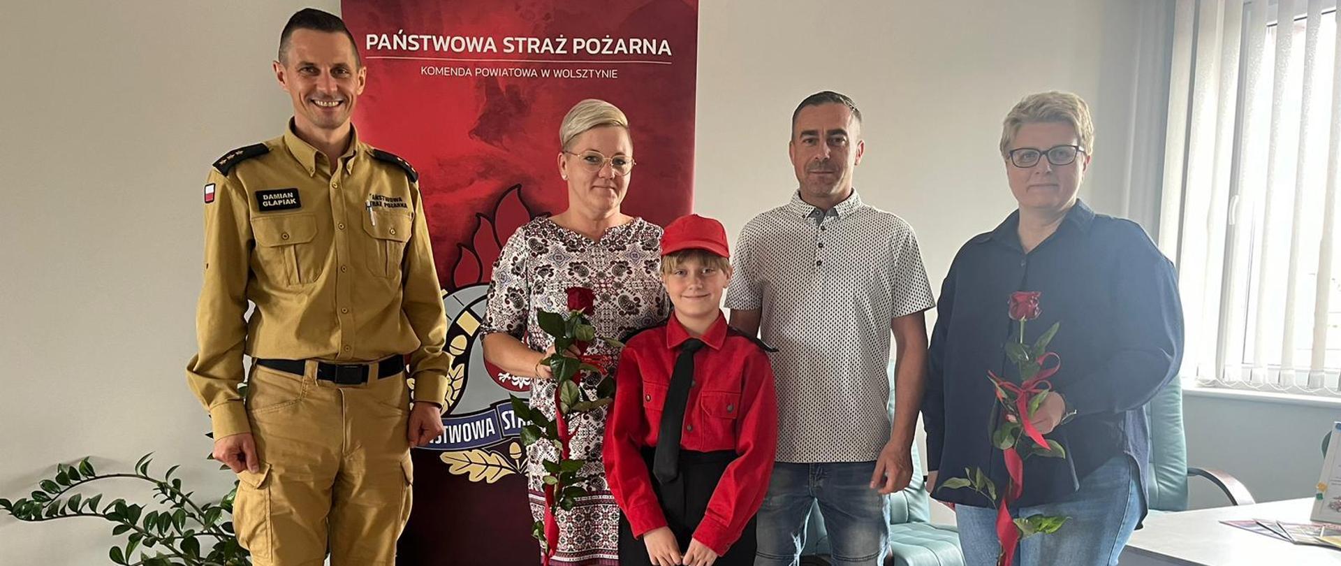 Na zdjęciu komendant powiatowy wraz z laureatką Ogólnopolskiego Turniej Wiedzy Pożarniczej, jej rodzicami oraz opiekunką MDP
