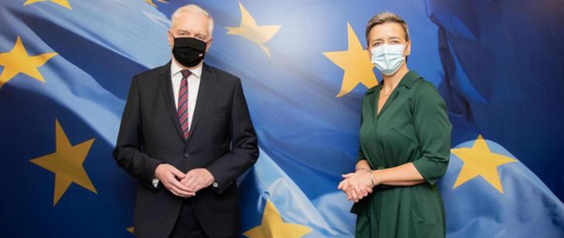 Vice Prime Minister and Minister of Development, Labour and Technology Jarosław Gowin with a mask on his face; Executive Vice-President of the European Commission for Competition Margrethe Vestager stands on his right side. At the back there is a flag of the EU.
