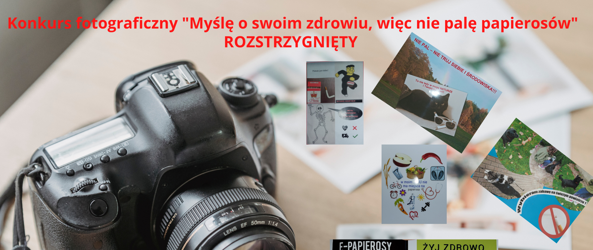 na blacie zdjęcia prac konkursowych, obok aparat fotograficzny. Czerwony napis Konkurs fotograficzny ,,Myślę o swoim zdrowiu, więc nie palę papierosów" rozstrzygnięty.
Na dole logo inspekcji i czarny napis Powiatowa Stacja Sanitarno-Epidemiologiczna