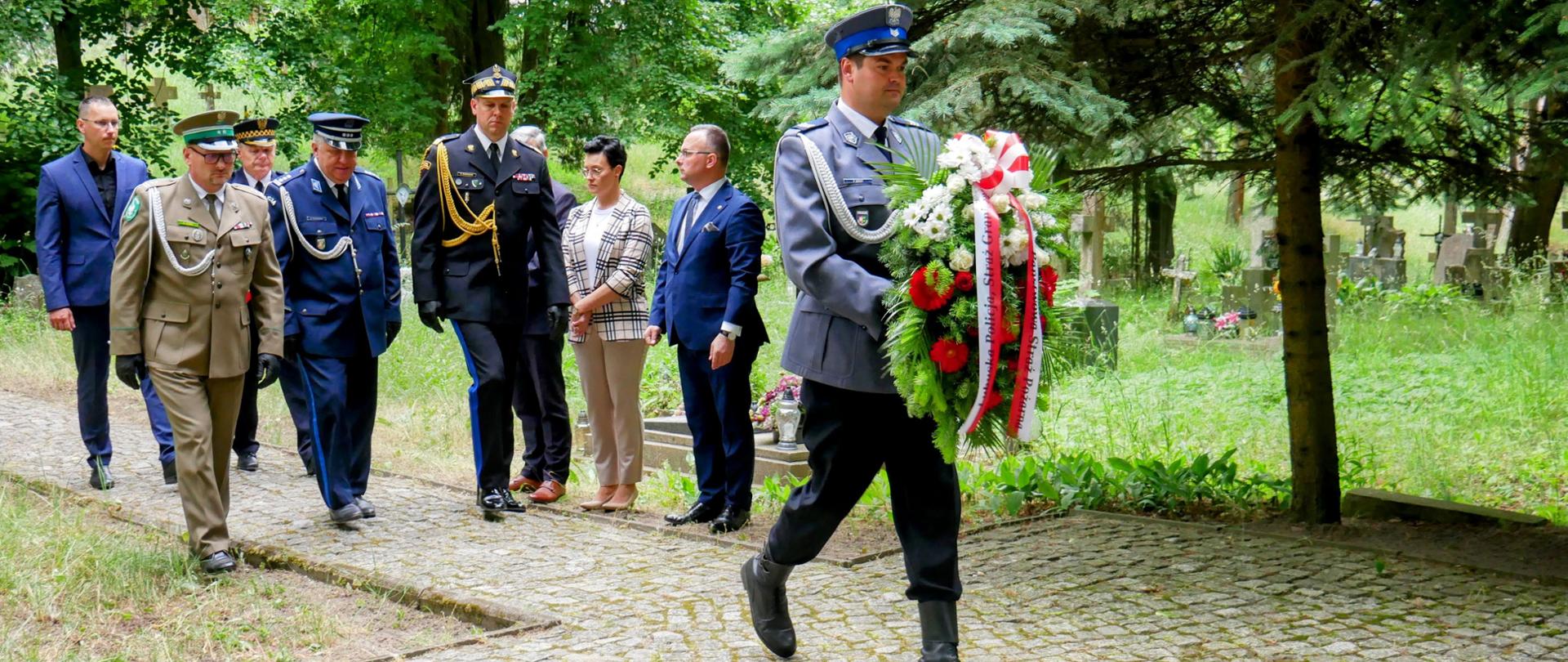 Narodowy Dzień Pamięci Ofiar Niemieckich Nazistowskich Obozów Koncentracyjnych i Obozów Zagłady - przedstawiciele służb podchodzą do pomnika