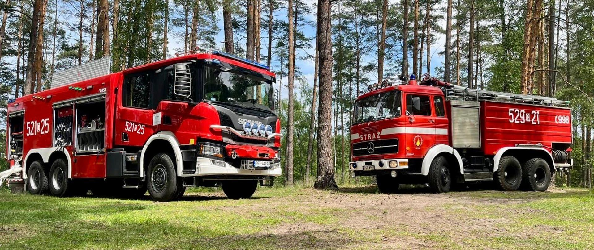 Dwa ciężkie samochody pożarnicze na tle lasu