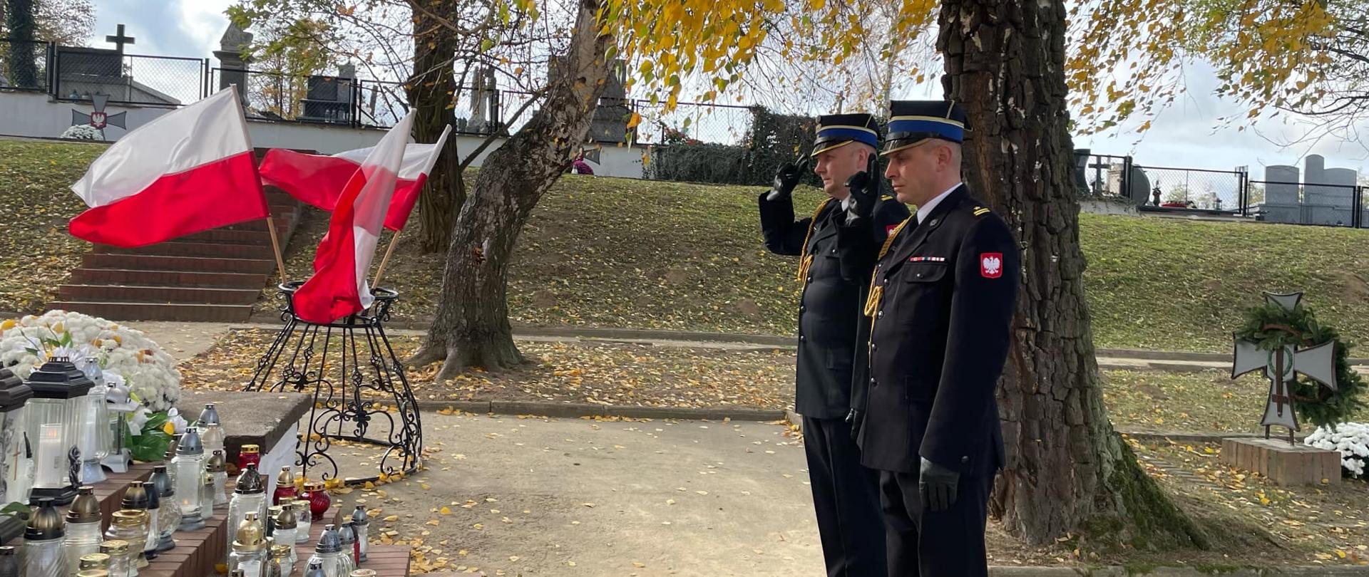 Strażacy oddający honor przed nagrobkiem