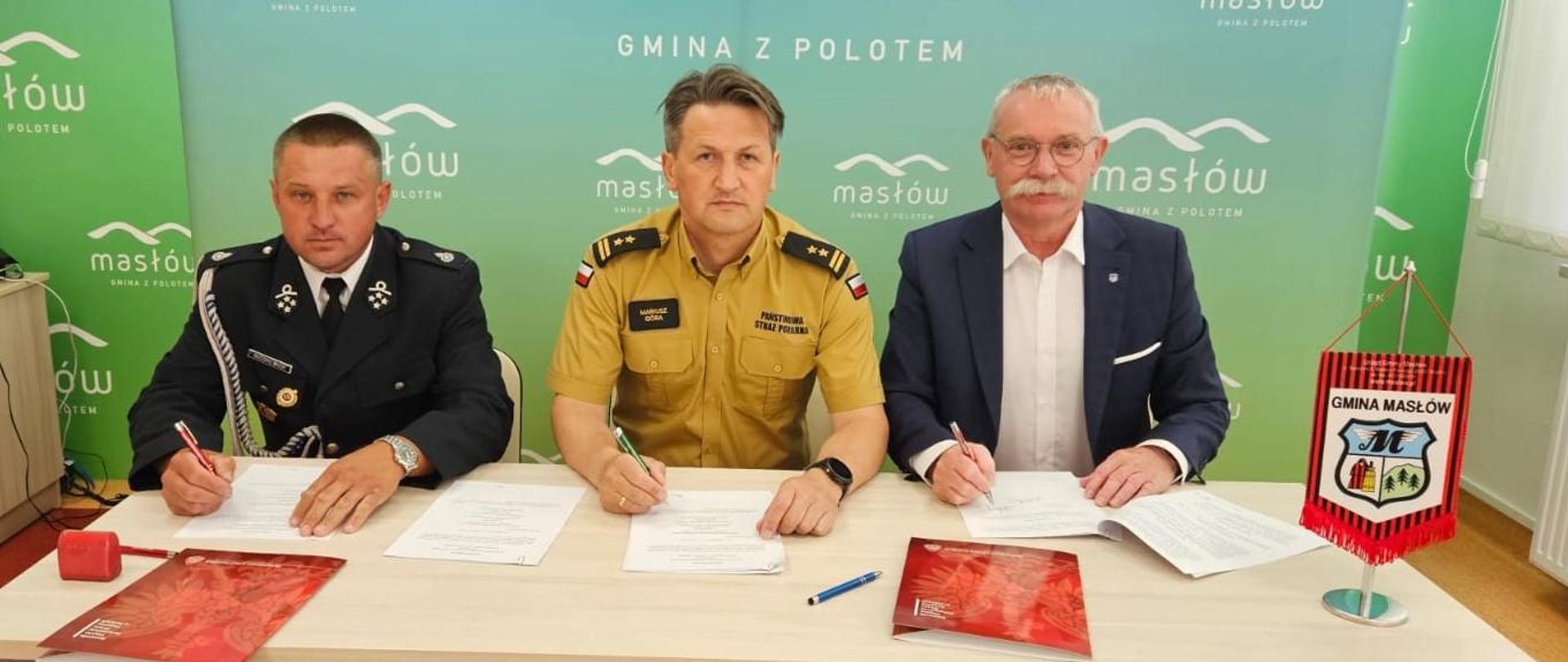 Zdjęcie przedstawia osoby podpisujące porozumienie o przynależności do KSRG jednostki OSP Wola Kopcowa w Urzędzie Gminy Masłów. 