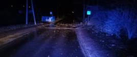 Na zdjęciu w porze nocnej widać zerwaną linię niskiego napięcia elektrycznego leżącą na jezdni w Ostrowcu Św. Zdjęcie wykonane z kokpitu samochodu ratowniczo-gaśniczego