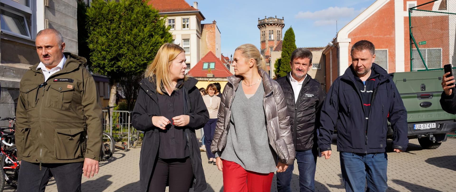 Ministra Edukacji wraz z pozostałymi czterema osobami idzie w rzędzie i spaceruje po Nysie. 