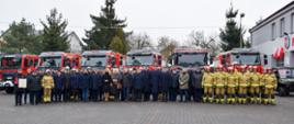 Na tle przekazanych samochodów zbiorowe zdjęcie przybyłych gości, funkcjonariuszy Państwowej Straży Pożarnej oraz druhów Ochotniczych Straży Pożarnych.