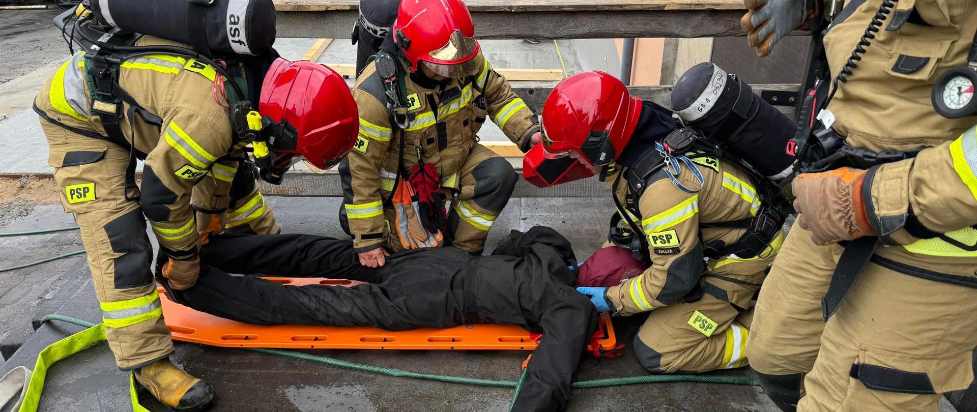 Strażacy udzielają pierwszej pomocy osobie poszkodowanej