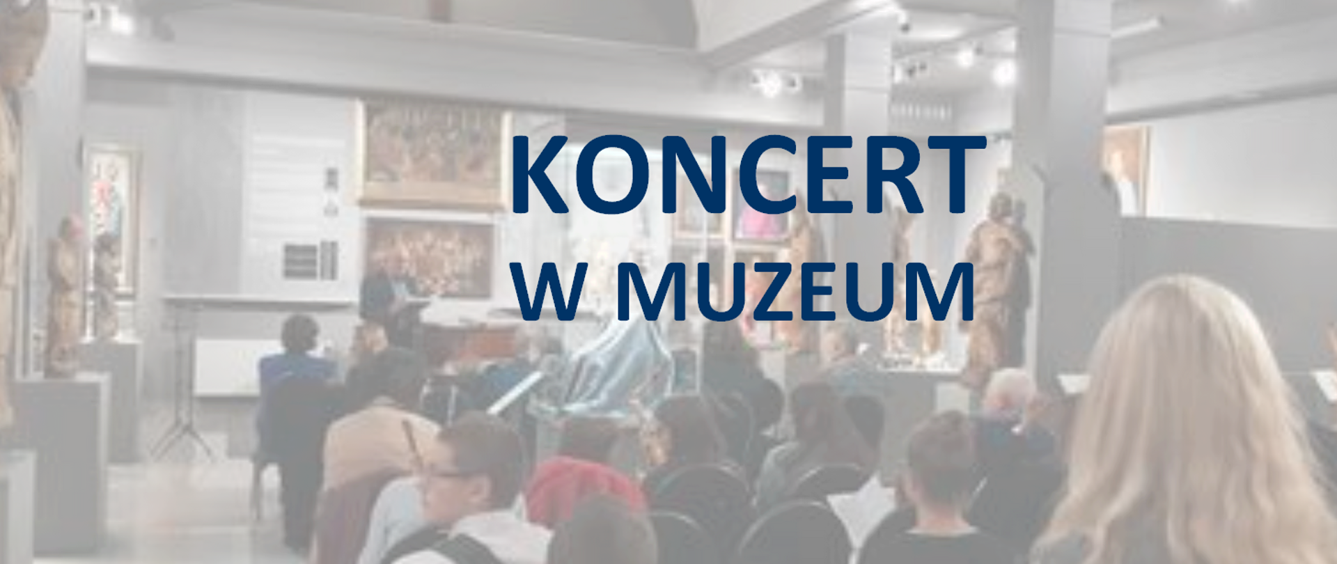 Zdjęcie przedstawiające wnętrze muzeum. Na ścianach wiszą obrazy. Pod ścianami stoją rzeźby. Na środku sali grupa ludzi siedząca na krzesłach i słuchająca koncertu.