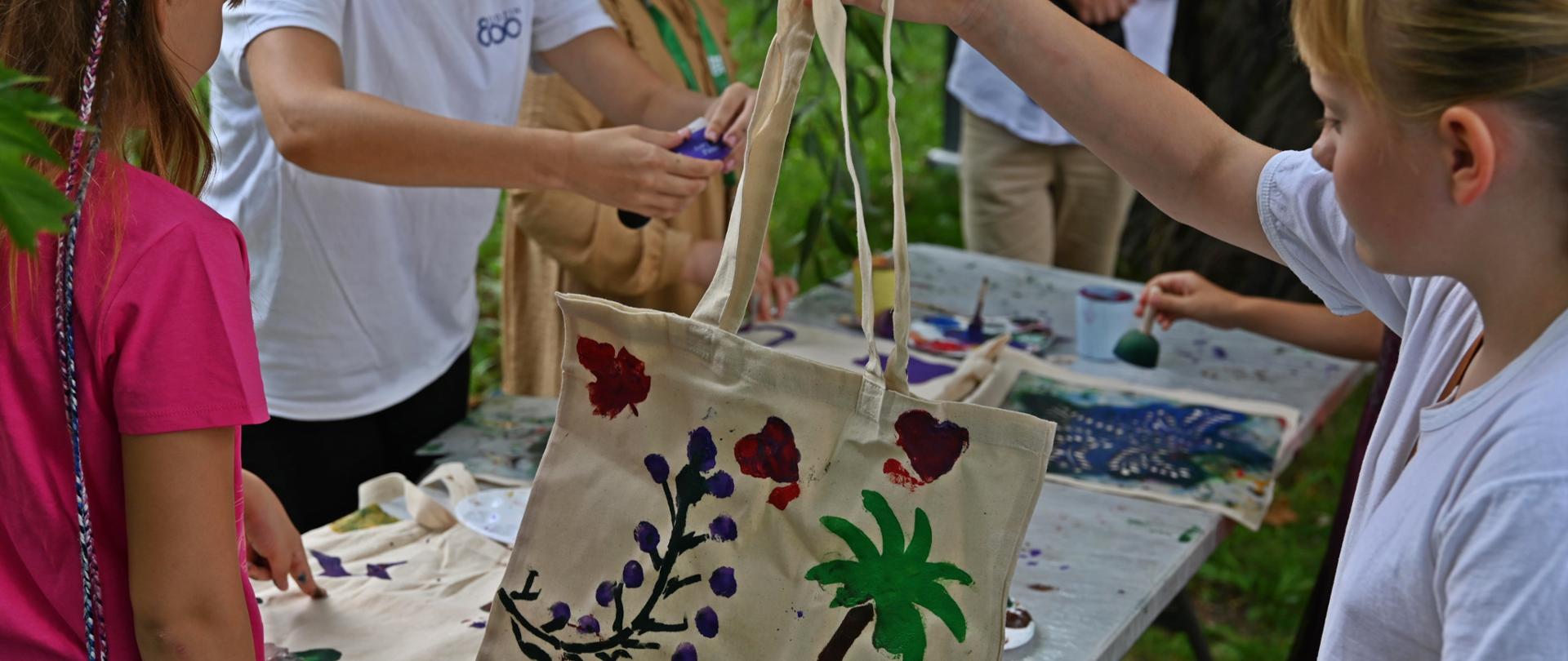 Dzieci dekorują materiałowe torby 
