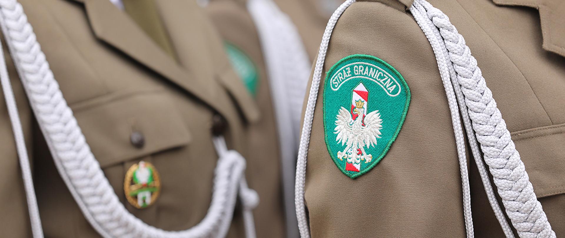 Fragment munduru galowego polskiej Straży Granicznej, widoczna naszywka naramienna SG.