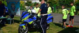 Policjant prezentuje motocykl policyjny uczestnikom turnieju