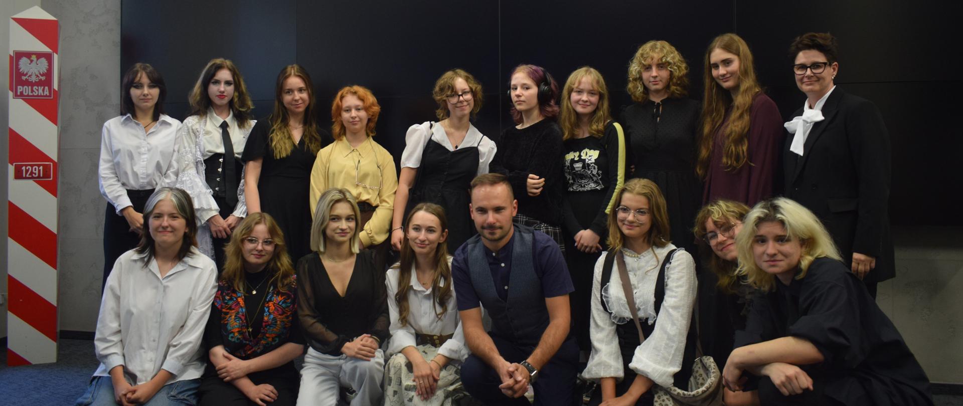 Grupa uczniów i osoby dorosłe pozuje do zdjęcia w sali IPN w Lublinie . W pierwszym rzędzie część z nich klęczy wraz z Tomaszem Banaszkiewiczem. Wyżej za nimi inni uczniowie stoją razem z kobietą.