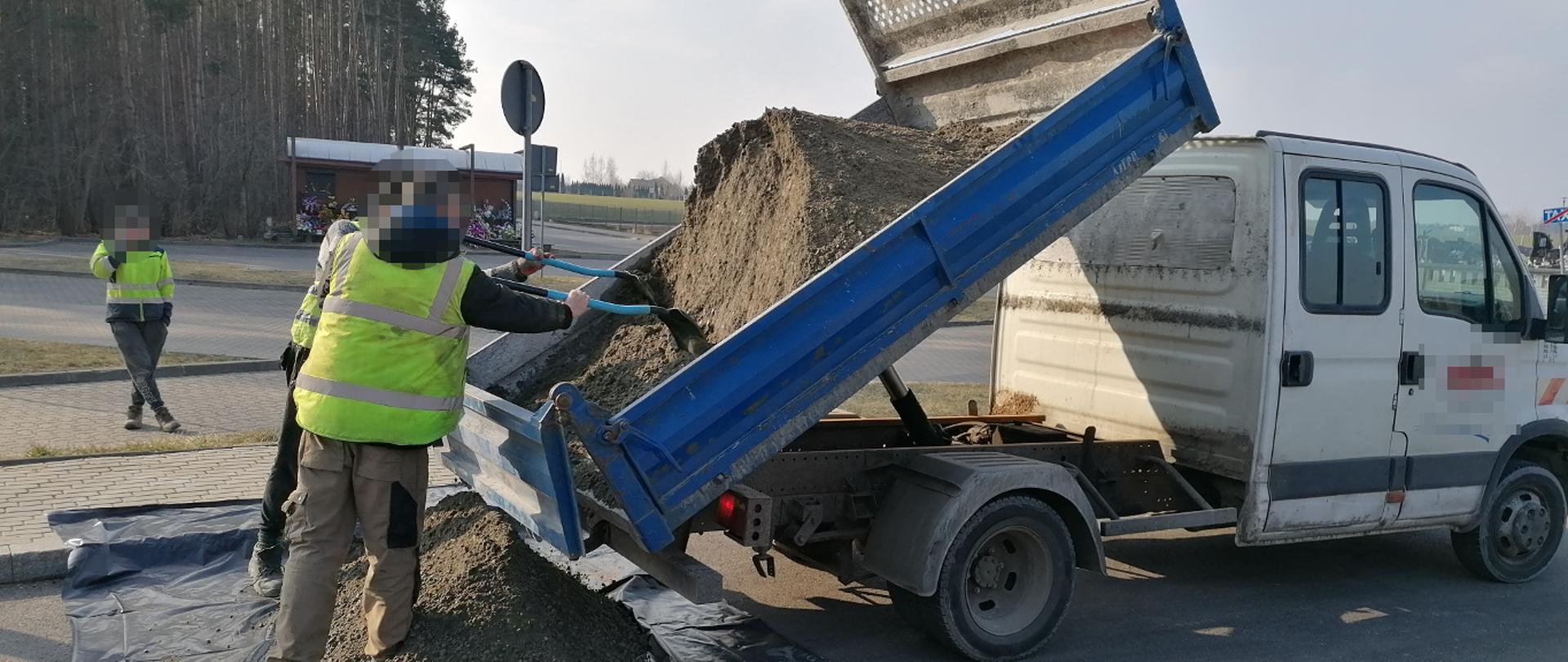 Pracownicy wyładowują sypki towar z przeciążonego busa