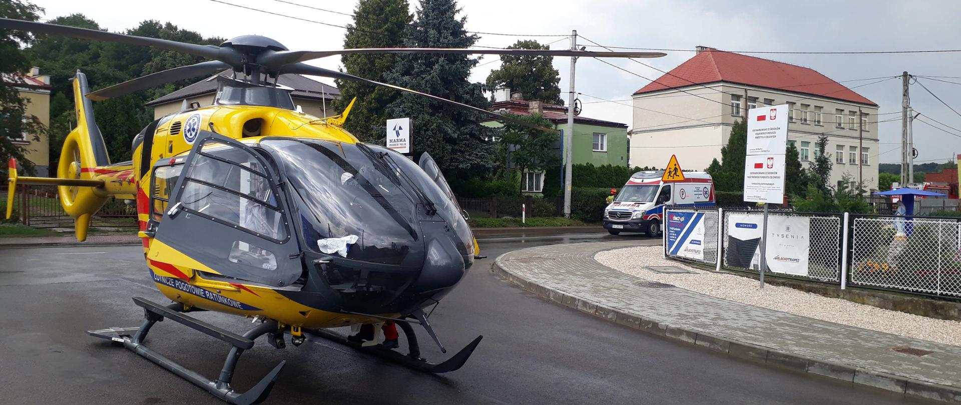 Zdjęcie przedstawia miejsce lądowania LPR. Na dalszym planie widać ambulans.