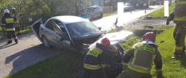 Strażacy odłączają źródło zasilania elektrycznego samochodu