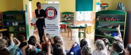 Obraz przedstawia prowadzącą oraz grupę zadających pytania na temat zasad higieny w życiu codziennym dzieci w wieku pięciu i sześciu lat. W tle znajduje się logo Powiatowej Stacji Sanitarno-Epidemiologicznej w Gdańsku. 