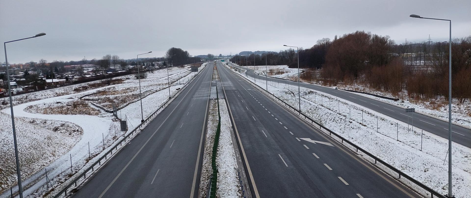 Droga ekspresowa S11 w scenerii zimowej. Dwujezdniowa droga ekspresowa po dwa pasy ruchu w obu kierunkach będąca obwodnicą Szczecinka.
