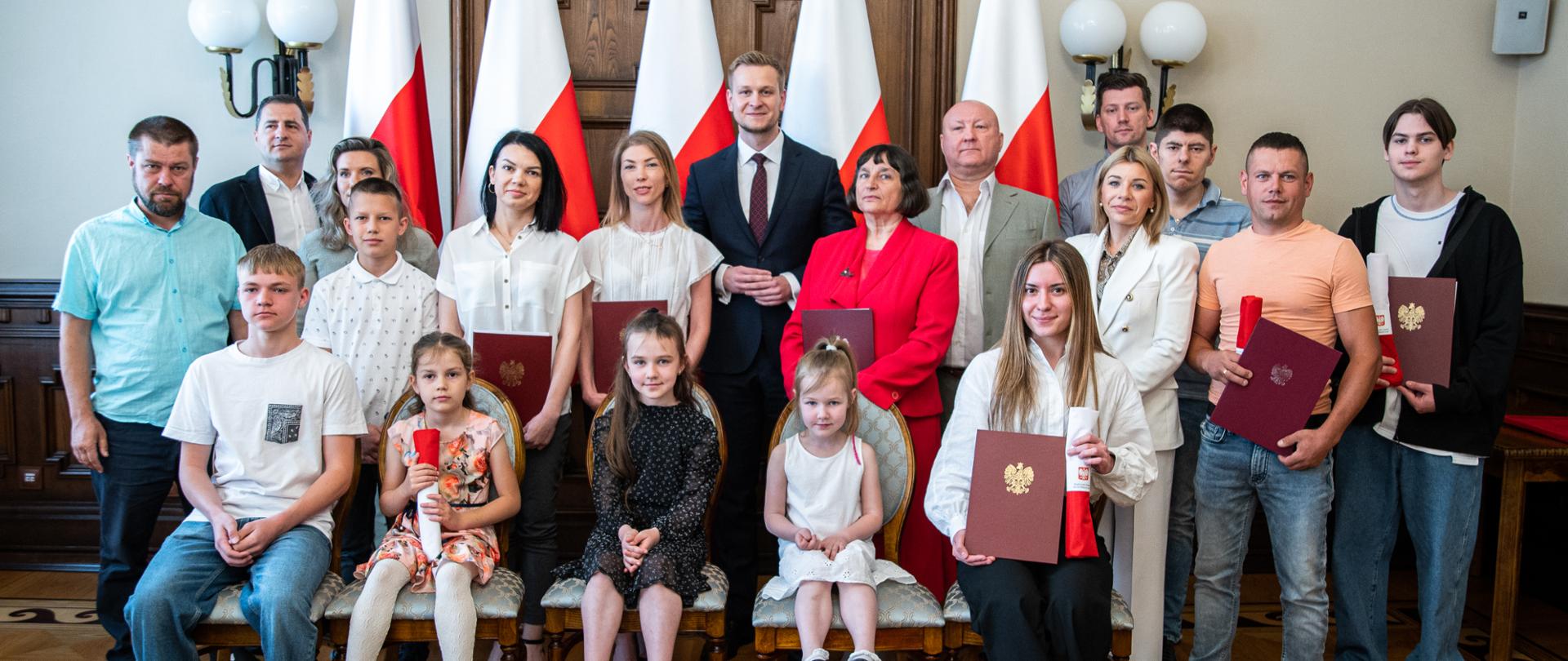 Zdjęcie wspólne I wicewojewody łódzkiego Marcina Buchali i nowych obywateli RP