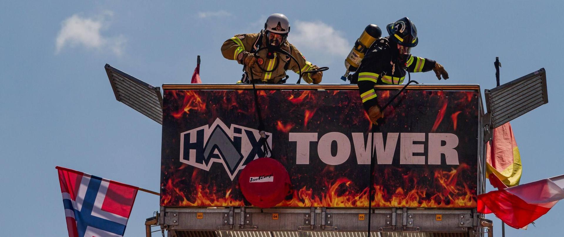 dwóch strażaków - zawodników na szczycie wieży