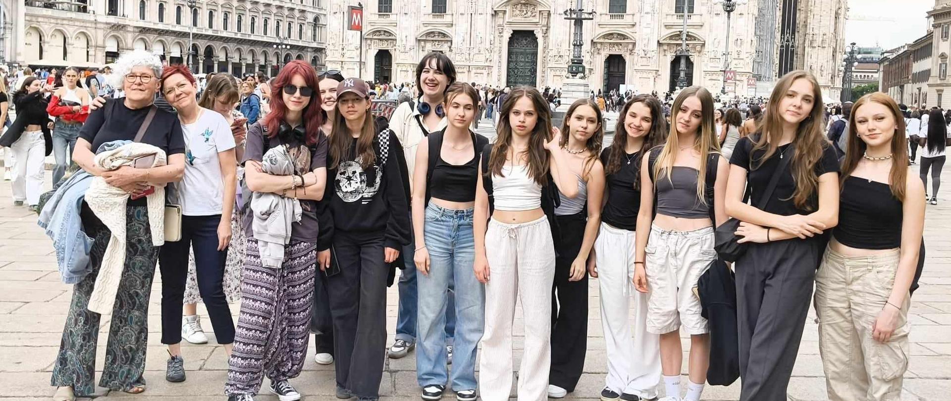 Grupa dziewcząt pozuje do zdjęcia , w tle katedra Duomo.