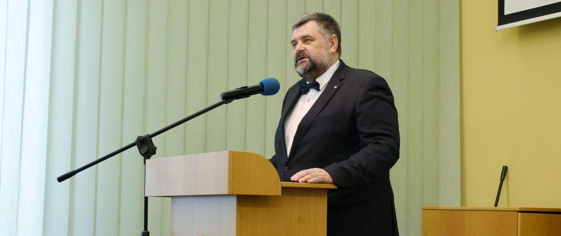 Dyrektor Instytutu Śląskiego dr Bartosz Kuświk. Na zdjęciu widać jak stoi przy mównicy i przemawia do uczestników uroczystości. 