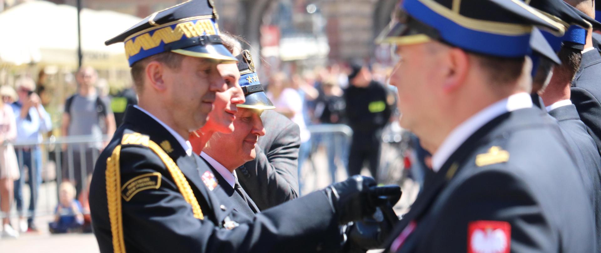 Komendant główny PSP dekoruje medalami zasłużonych strażaków.