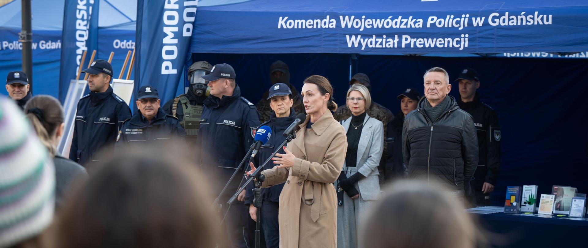 kobieta (wojewoda) stoi na placu przed mikrofonem i przemawia