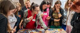 A group of women standing next to a desk with colourful playing cards