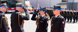 Zastępca komendanta głównego PSP salutuje do wyróżnionej kobiety oficer.