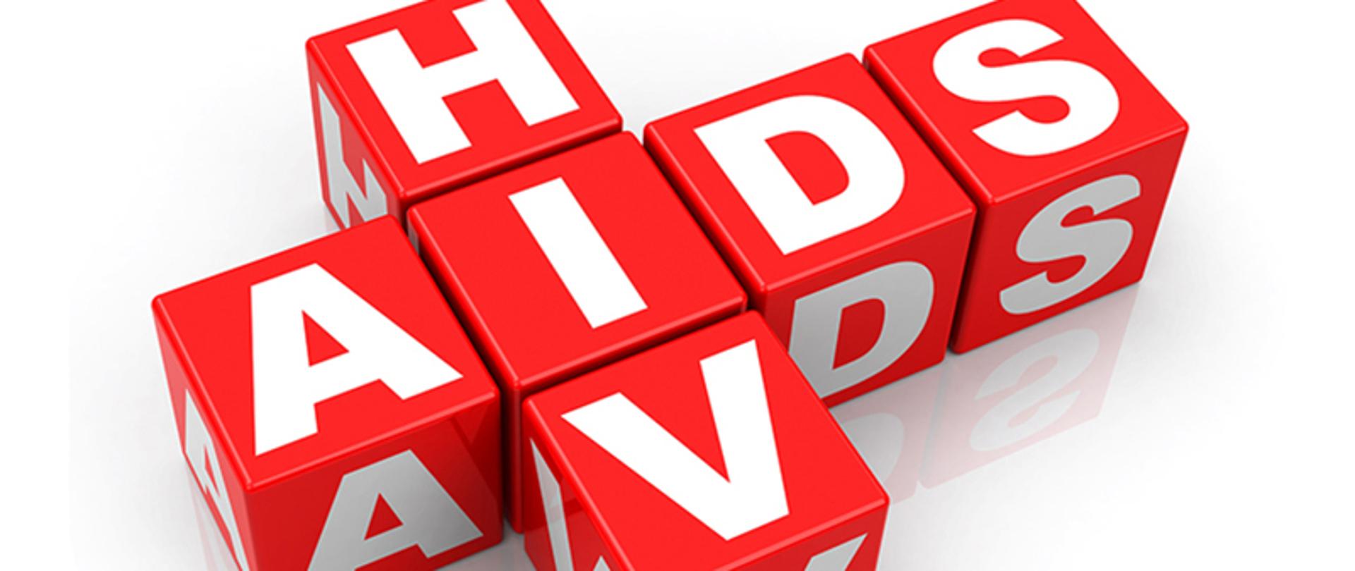 Zdjęcie przedstawia biały napis 'HIV/AIDS', umieszczony na czerwonych kostkach (sześcianach) na białym tle.
