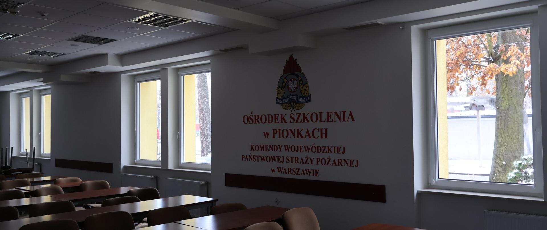 Wnętrze pomieszczenia szkoleniowego z trzema oknami