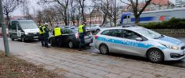 Pomiędzy stojącymi samochodami inspekcji oraz policji, poddawany kontroli pojazd z oznaczeniami TAXI. Obok stojące osoby dokonujące kontroli: policji oraz inspekcji.