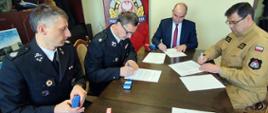 Podpisanie porozumienia – przy stole siedzą od lewej: naczelnik OSP Ryczów, prezes OSP Ryczów, wójt gminy Spytkowice, komendant powiatowy PSP w Wadowicach.