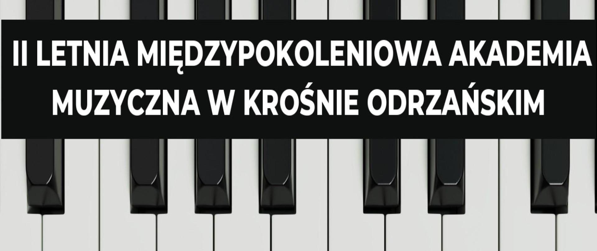 Na klawiaturze fortepianu na czarnym prostokącie znajduje się napis II Letnia Międzypokoleniowa Akademia Muzyczna w Krośnie Odrzańskim.
