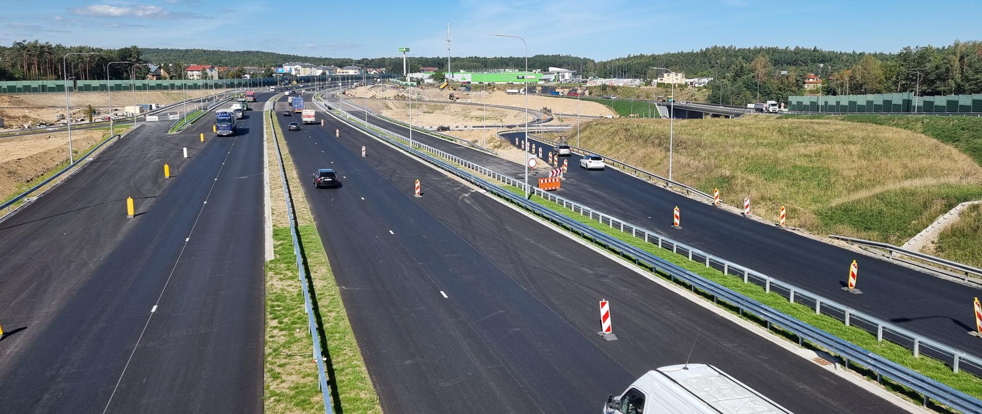 Budowa drogi ekspresowej S6 na węźle Gdynia Wielki Kack. Na pierwszym planie nowe jezdnie Obwodnicy Trójmiasta w oddali strefa robót budowlanych.