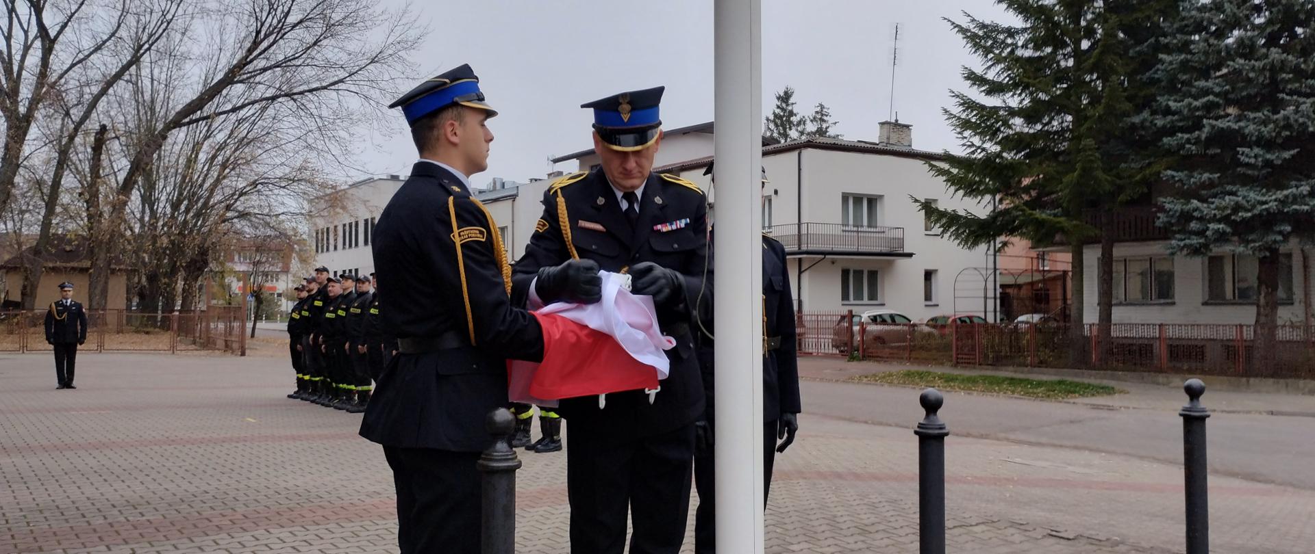 Poczet flagowy podpina flagę do masztu.