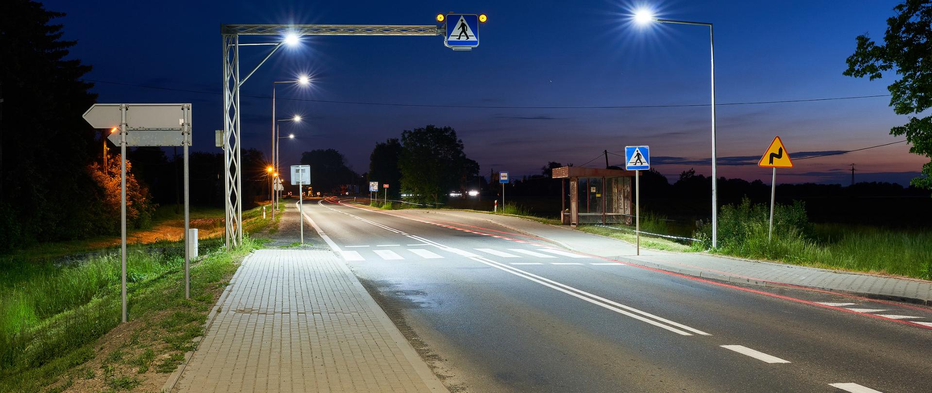 DK94 Korczowa widok w porze nocnej na chodnik i oświetlone przejście dla pieszych.