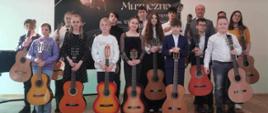 Zdjęcie przedstawiające wszystkich wykonawców koncertu uczniów klas gitary, który odbył się 25 marca 2024 roku w auli szkoły.