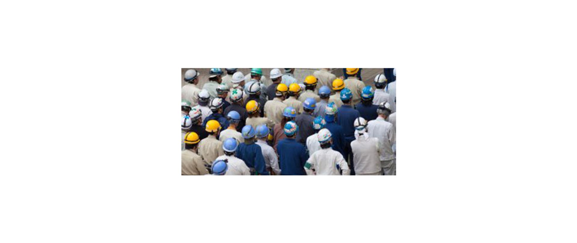 Na zdjęciu: grupa robotników w kaskach i strojach roboczych