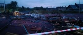 Zerwany dach budynku szkoły na płycie boiska sportowego